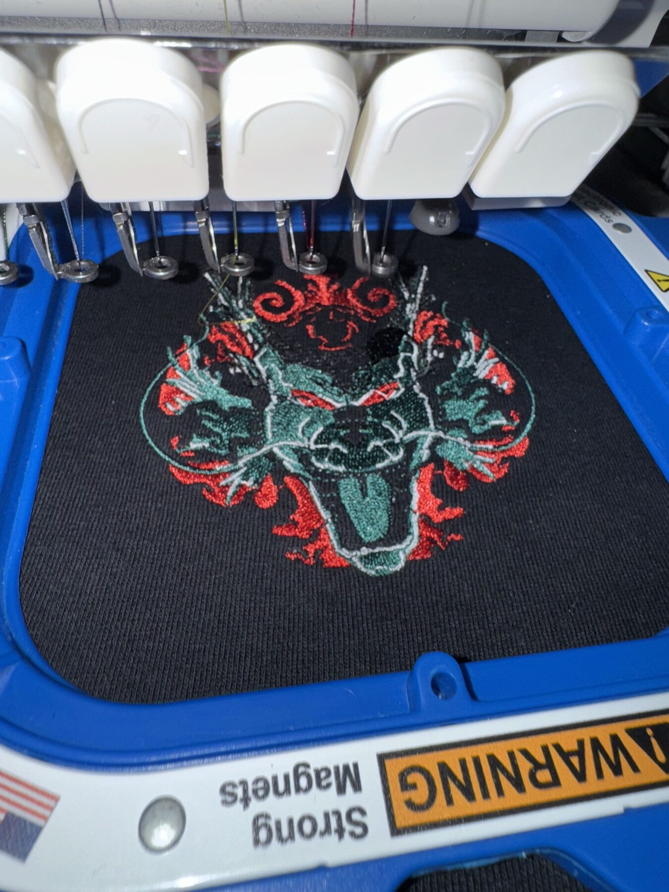 Embroidery machine stitching a detailed dragon design